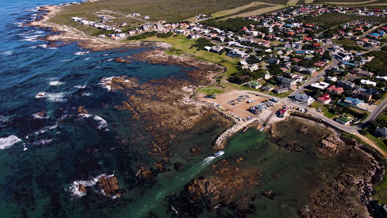 상어 케이지 다이빙 보트는 바위가 많은 여울을 통해 좁은 채널을 탐색합니다.