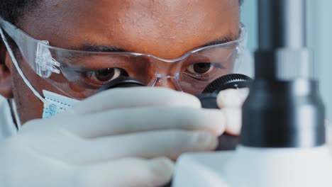 scientist using a microscope in a lab