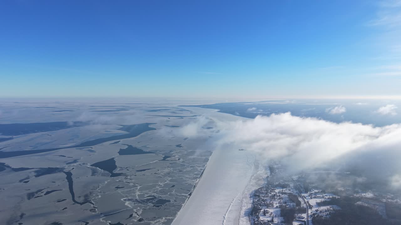 Luftfoto af overskyet himmel over frossen kystlinje, fredfyldt vinterlandskab.