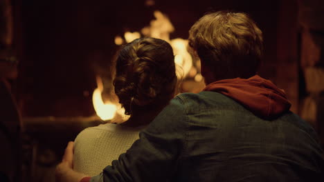 romantic couple embrace cuddle on love date. two lovers enjoy look fireplace.