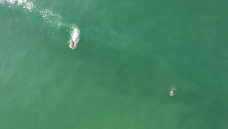bodyboarder vistiendo una lycra roja atrapando una ola y haciendo algunas maniobras