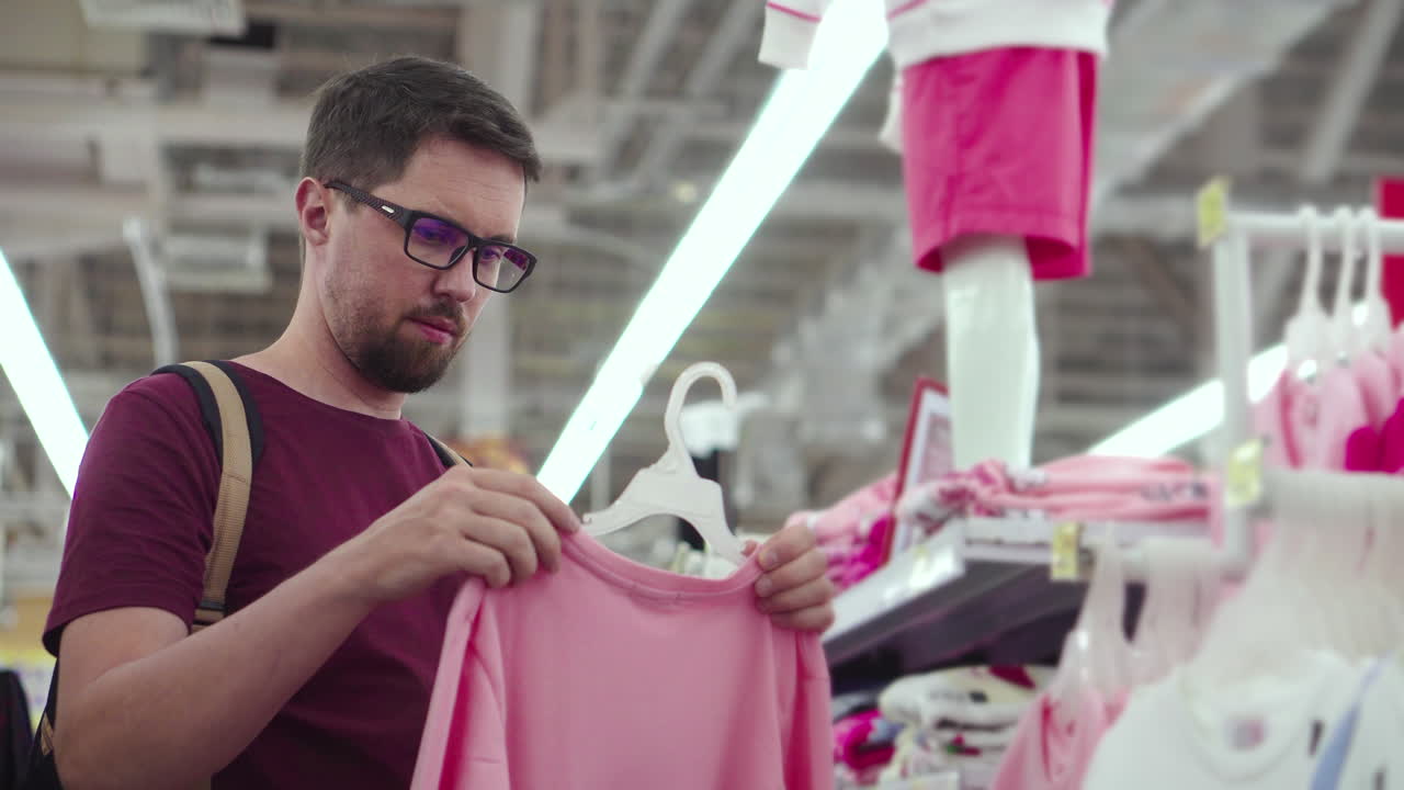 hombre comprando ropa para niños en una tienda minorista