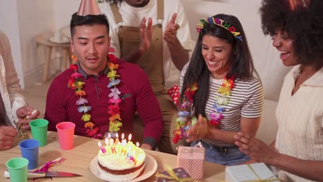 friends celebrating a birthday party with cake and gifts