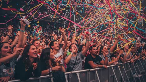 captivating moments of joy and celebration: audience enthusiasm unleashed during a vibrant music event with colorful confetti and energetic crowd participation