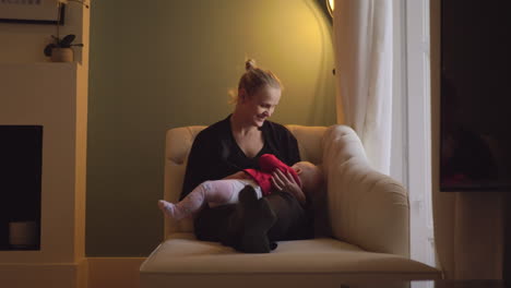 madre feliz amamantando a su hija de ocho meses