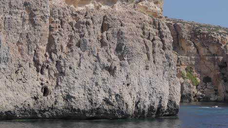 Vorbei-An-Der-Crystal-Lagoon-In-Comino,-Malta,-Einer-Geschützten-Bucht,-Die-Von-Hoch-Aufragenden-Kalksteinfelsen-Eingerahmt-Wird