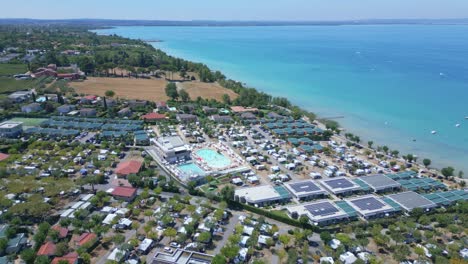 campsite on lake garda shoreline on beautiful summer day, aerial