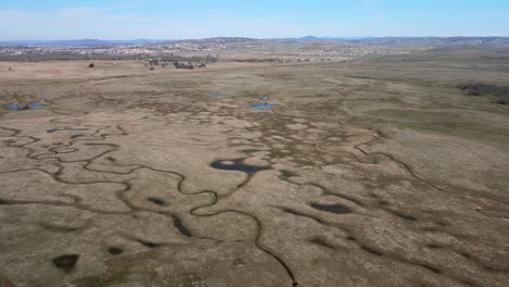 realtime drone footage over prairie city country park, california, usa, showing wide open scrubland countryside and waterways, on a warm morning with blue sky