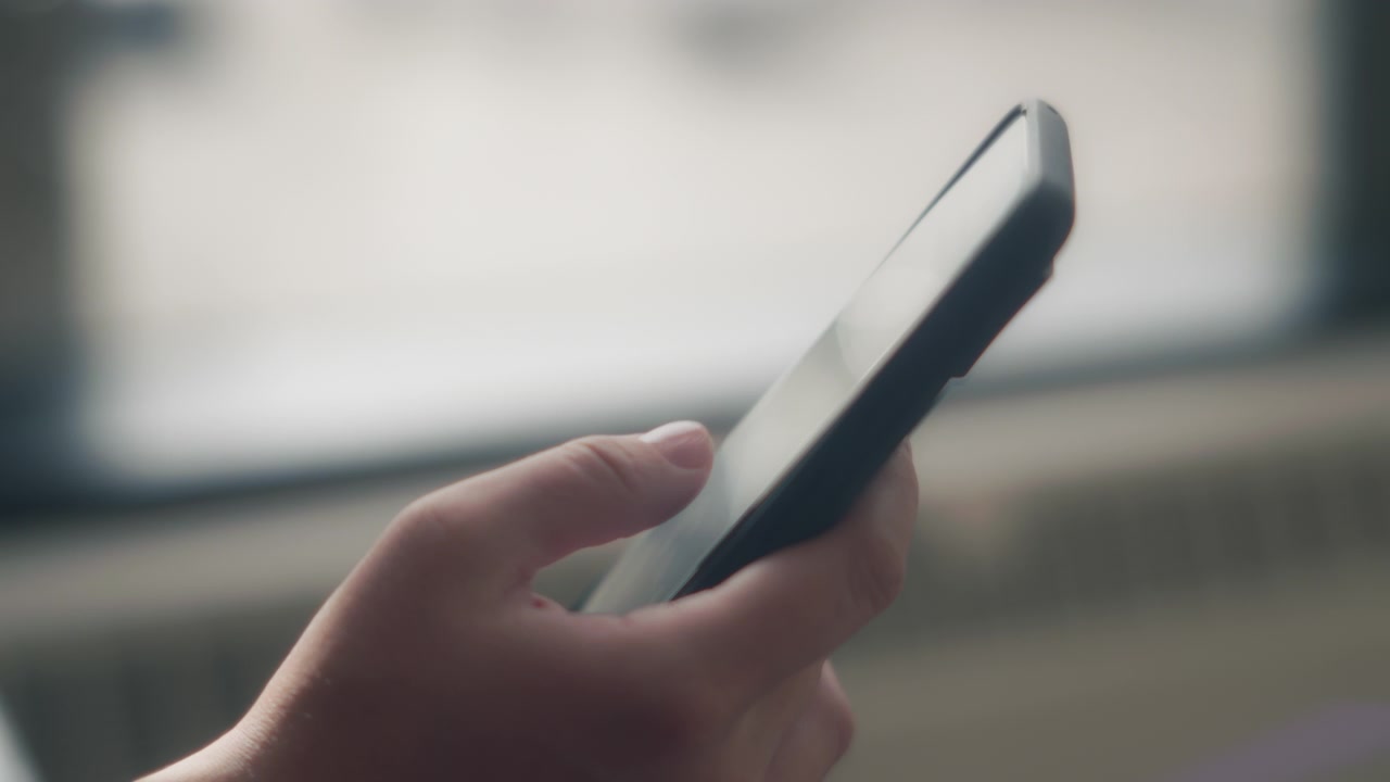 Primo piano di una donna che tiene uno smartphone e scorre