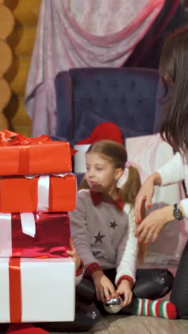 happy family with presents at christmas. little girls spend time together in christmas decorated room. vertical video