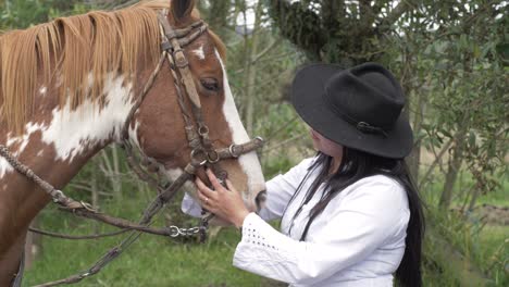 Slow-motion-video-of-latina-cowgirl-petting-her-horse