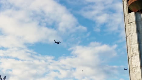 Helicópteros-Militares-De-La-OTAN-Boeing-Ch-47-Chinook-Volando-A-Baja-Altura-Sobre-Una-Zona-Poblada