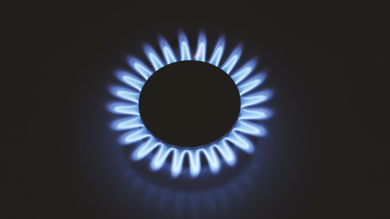 горящая газовая плита, синие пламя макро крупный план в темноте на черном фоне. 4k сырое видео.