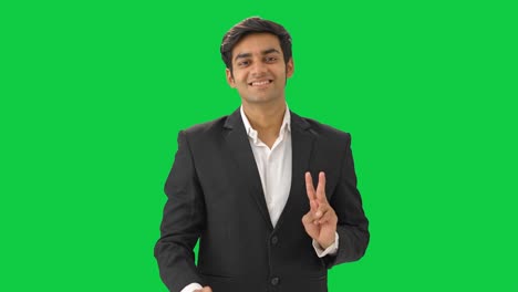 Happy-Indian-businessman-showing-victory-sign-Green-screen