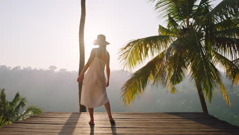 happy woman dancing celebrating vacation lifestyle on holiday with beautiful view of tropical jungle at sunrise 4k