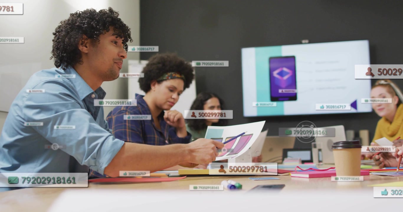 Holding swatch, man in blue shirt sliding samples across table, reviewing mockups with UI overlays