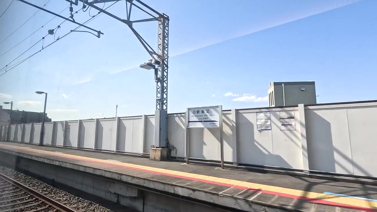 Vista da un treno in movimento che attraversa una stazione ferroviaria giapponese
