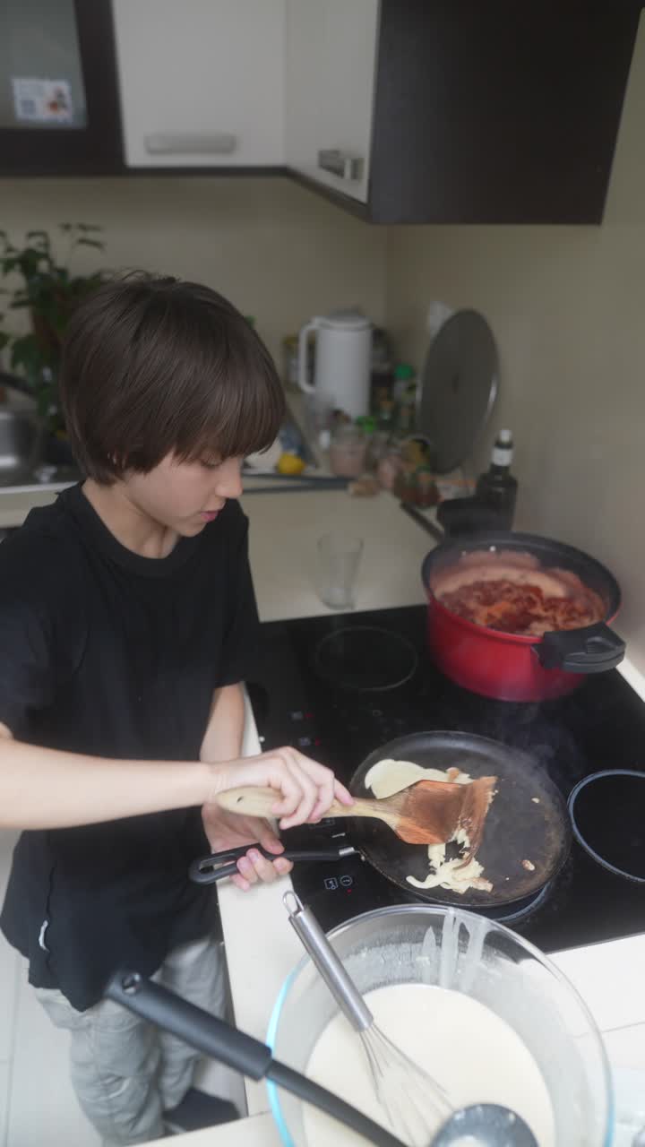 Boy Cooking Pancakes in Kitchen