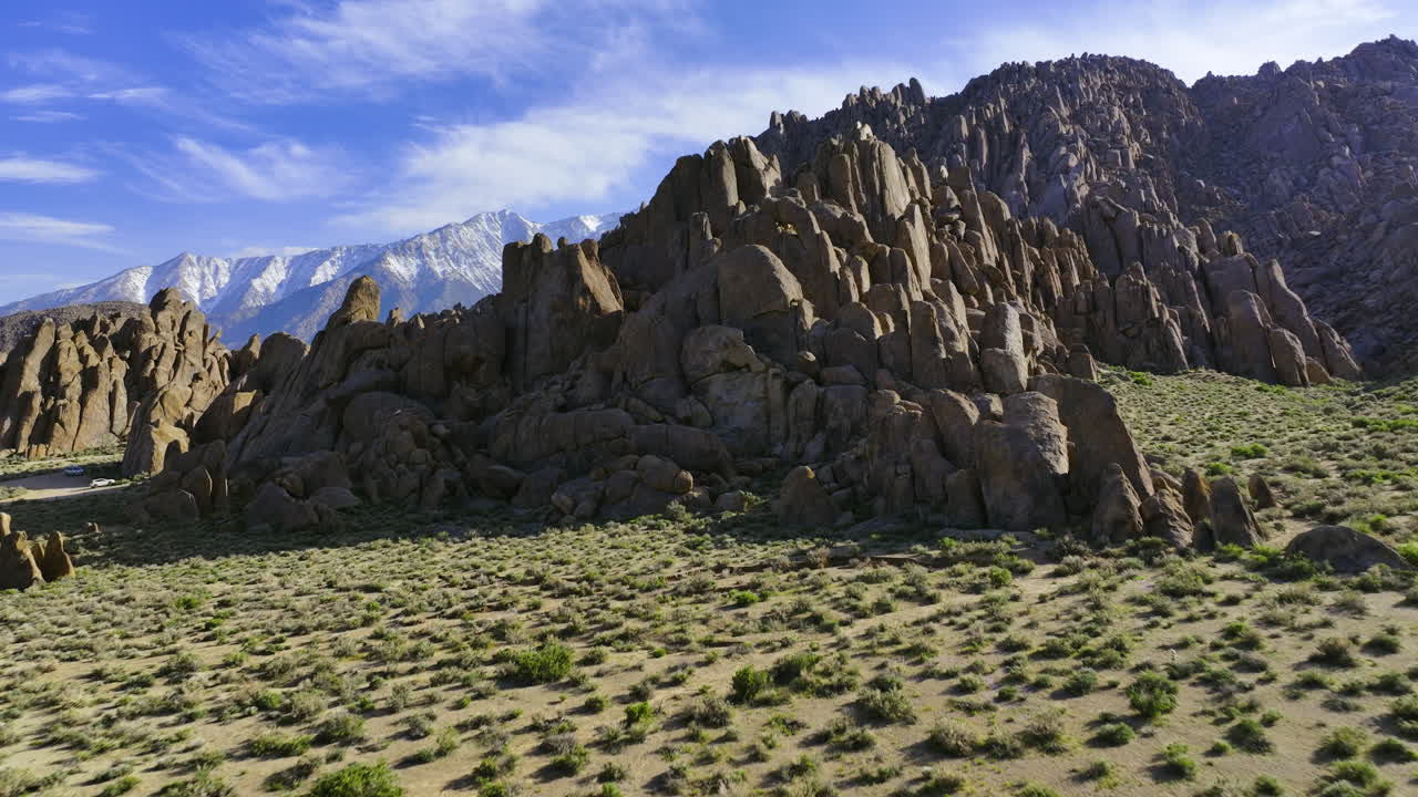 drone inclinándose hacia acantilados rocosos, día soleado en alabama hills, california, ee.uu.