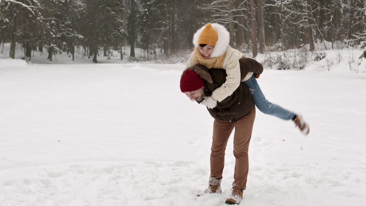 una pareja divirtiéndose en un parque nevado.