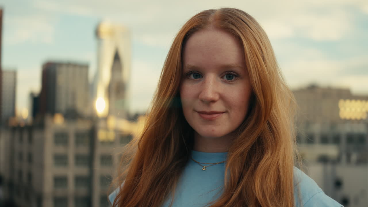 Portrait of a woman with red hair on a rooftop