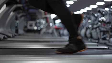 in der nähe von beinen joggt ein mann auf dem laufband im fitnessstudio