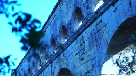 stone arches of pont du gard between nature