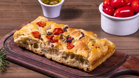 traditional italian focaccia with pepperoni, cherry tomatoes, black olives, rosemary ando onion - homemade flat bread focaccia