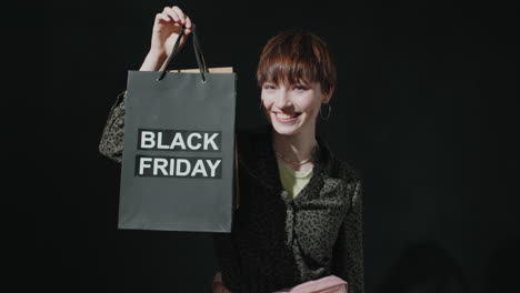 portrait of joyous girl with black friday shopping bag