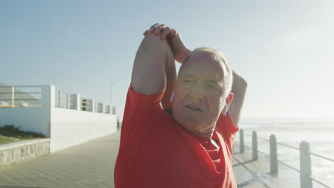 Senior-man-stretching-his-arms-on-the-promenade