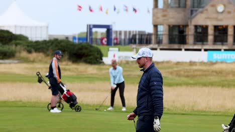 golfers playing on a field in st andrews