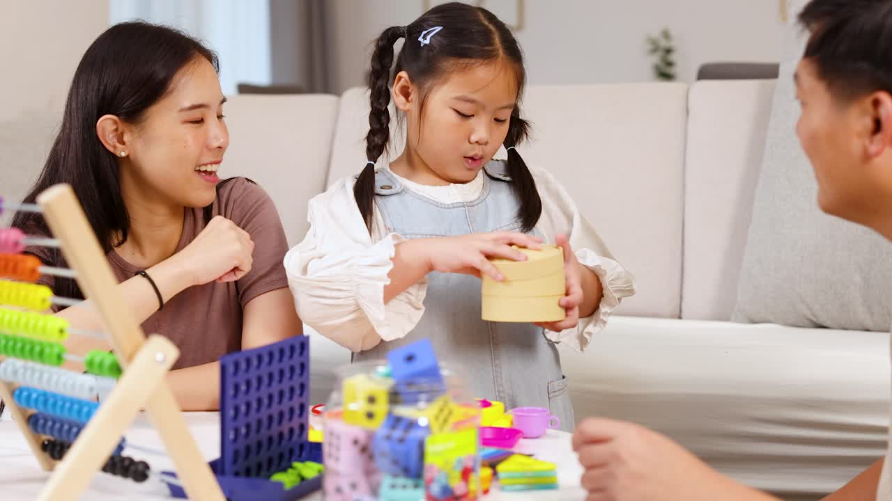 Parents and child interact with colorful educational toys in a bright, cozy living room setting