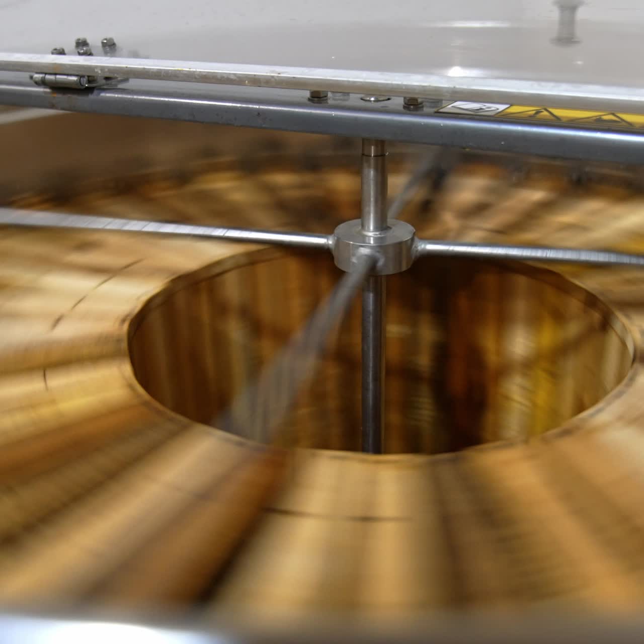 Organic honey frames spinning in the centrifuge apparatus. Special device for extracting honey at bee farms at work