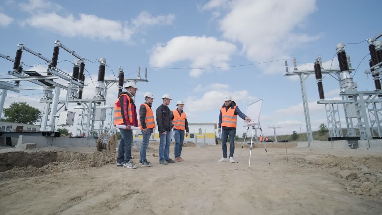 Engineers supervise the construction of a transformer substation
