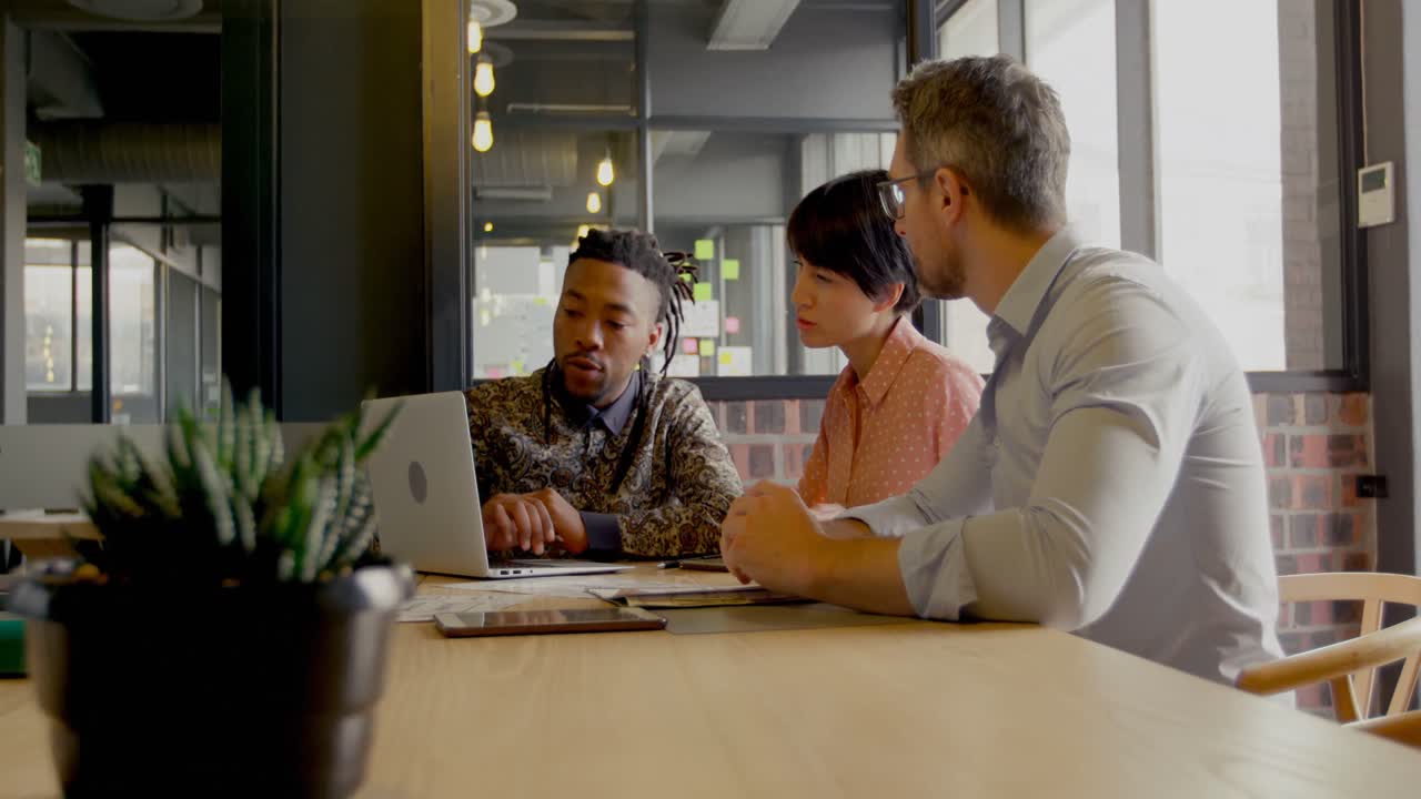 Business executives discussing over laptop in conference room 4k