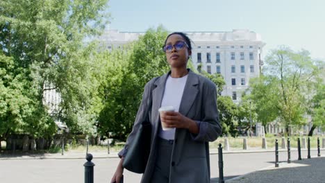 businesswoman walking in the city with coffee and phone