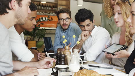 mixed race group of people small business startup team meeting in cafe