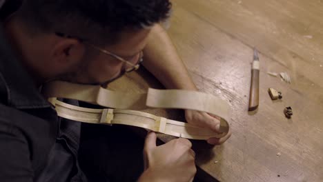 luthier creando costillas de violín en el taller