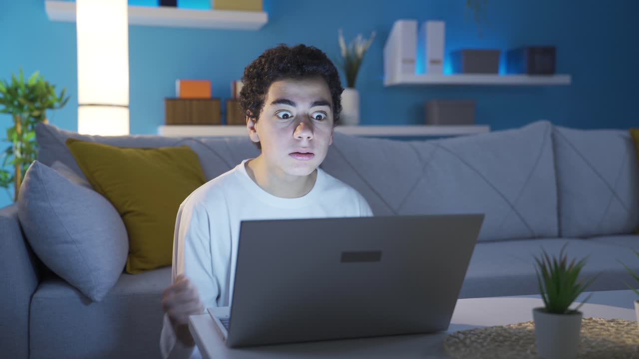 흥분과 공격성으로 노트북을 사용하는 소년.
