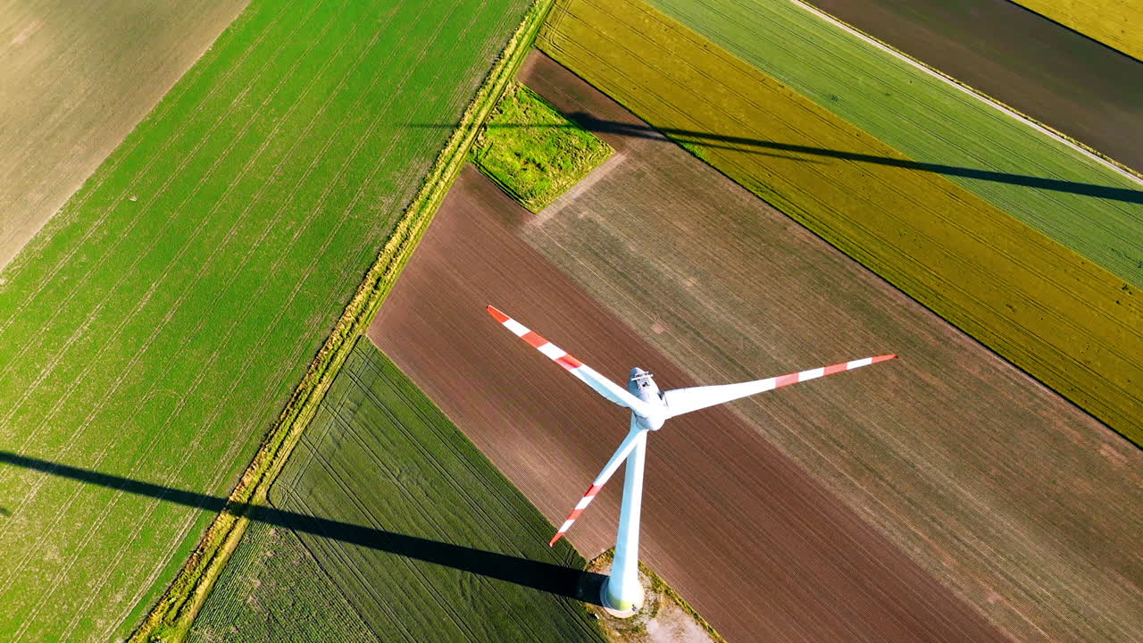 Long blades of wind turbine rotate in the wind. Top view on the windmill producing green energy.