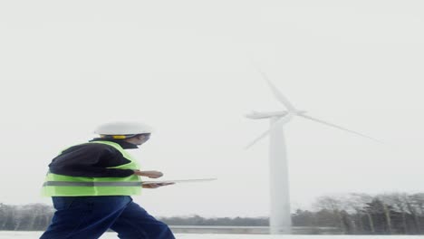 técnico de turbinas eólicas inspeccionando el sistema en invierno