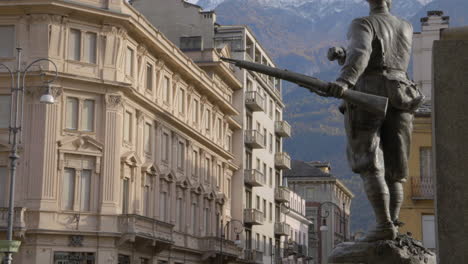 A-Bronze-statue-with-his-gun-in-front-of-the-town-hall-in-the-city-of-Aosta,-Italy