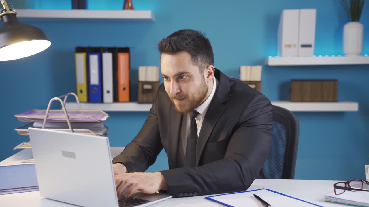 Uomo d'affari che lavora al portatile è molto felice per ciò che vede.
