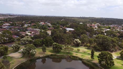 Inclinación-Aérea-Hacia-Abajo-Sobre-Un-Lago-Circular-Con-Vistas-A-Los-Matorrales-Circundantes---Joondalup,-Perth