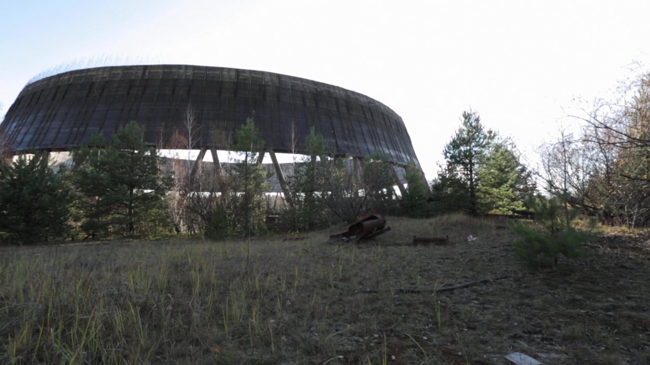 An unfinished cooling tower stands in the overgrown Chernobyl exclusion zone.