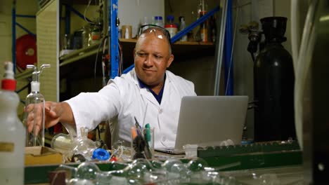 Front-view-of-mature-male-worker-examining-glass-product-in-glass-factory-4k