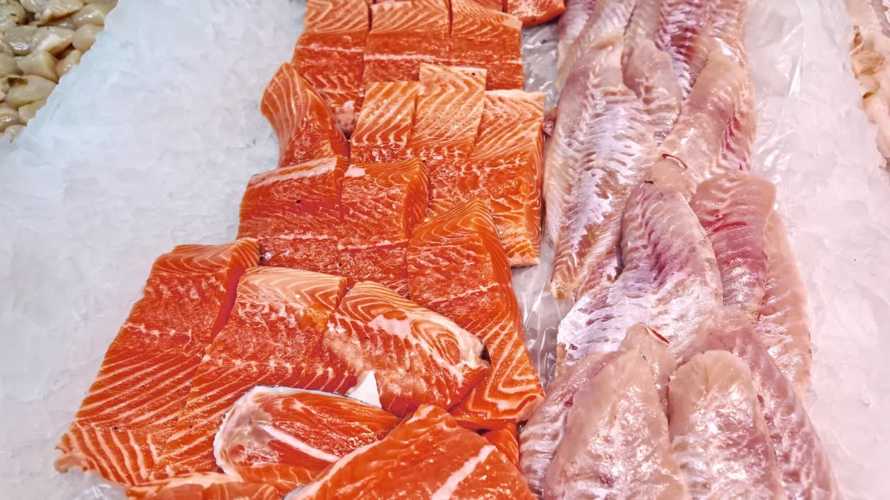 Fresh salmon and redfish fillets on ice at fish market. For food, culinary, and healthy eating content