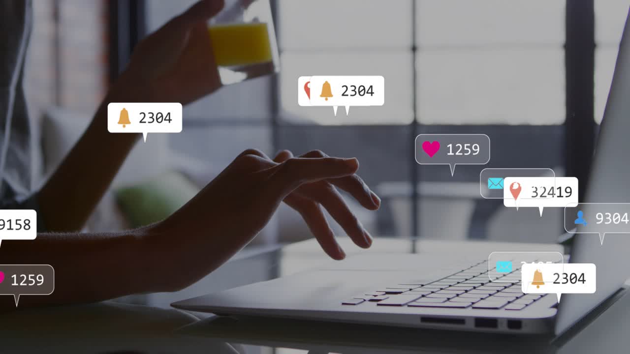 Woman resting hands on keyboard at business desk receiving notification bubbles and sipping juice