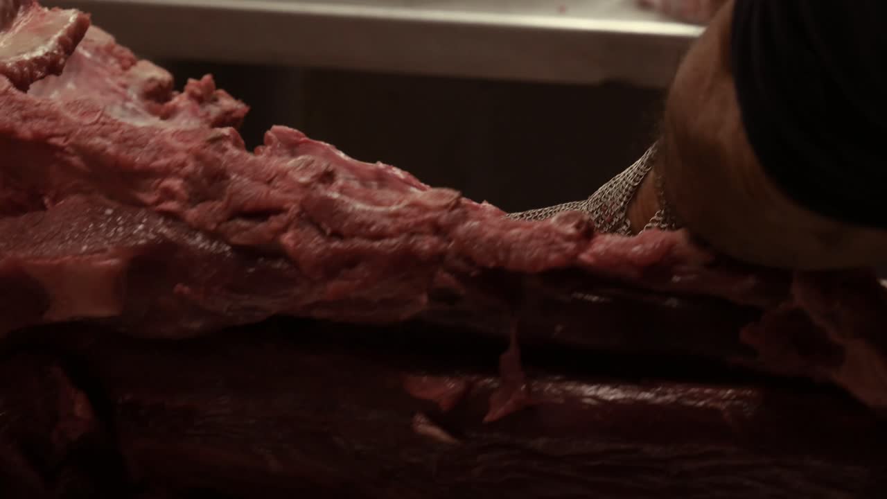 Macellaio che lavora la carne per la vendita in un mercato