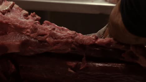 el carnicero está procesando carne para su venta en un mercado